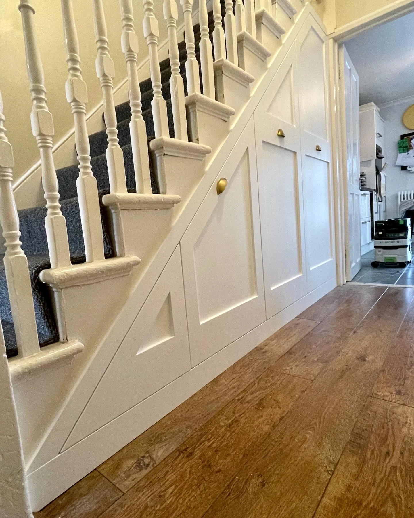 white custom cabinets under the stairs
